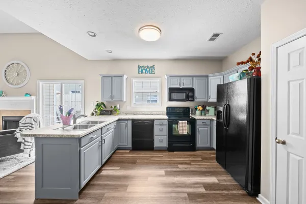 a kitchen with stainless steel appliances kitchen island granite countertop a refrigerator stove and sink