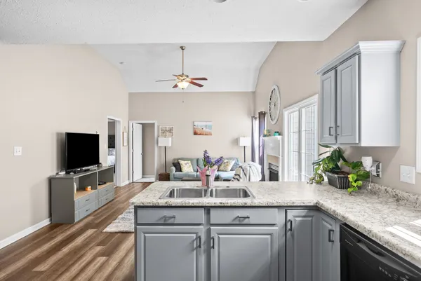 a kitchen with a sink and a flat screen tv