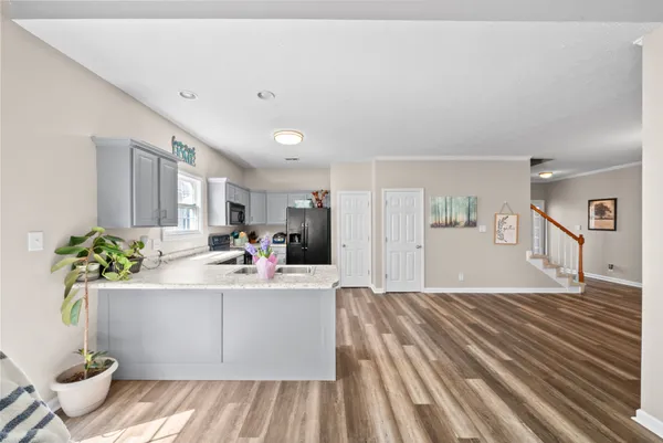 a living room with kitchen island furniture and a potted plant