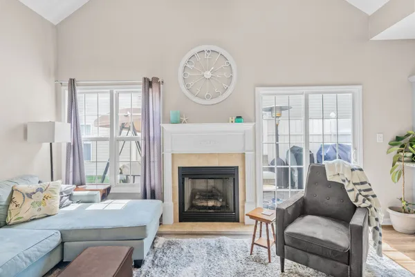 a living room with furniture a large window and a fireplace
