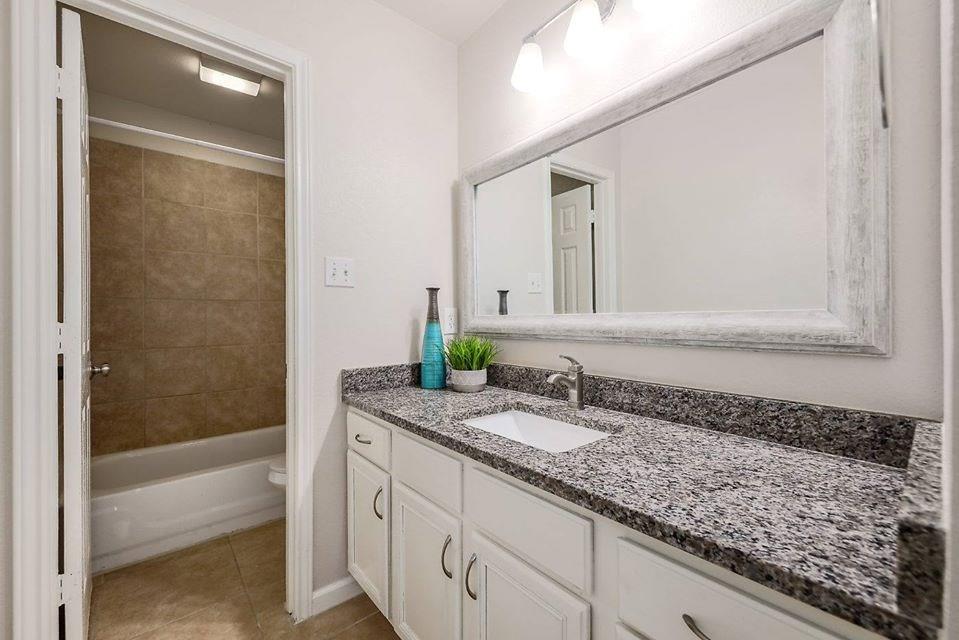 12307 Turtle Rock Road, Unit B Austin, TX 78729 - Photo 11 of 11 Full bath featuring vanity, light tile patterned flooring, and washtub / shower combination