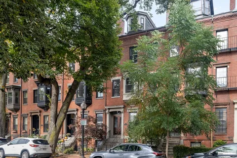 a front view of a multi story building with a yard