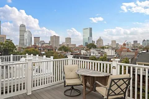 a view of a balcony with wooden benches