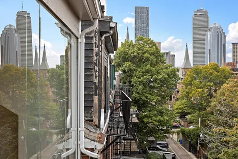 a view of a tall building next to a yard