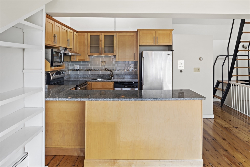 49 Worcester Street, Unit 4 Boston, MA 02118 - Photo 7 of 19 a kitchen with granite countertop a refrigerator a sink and wooden floors
