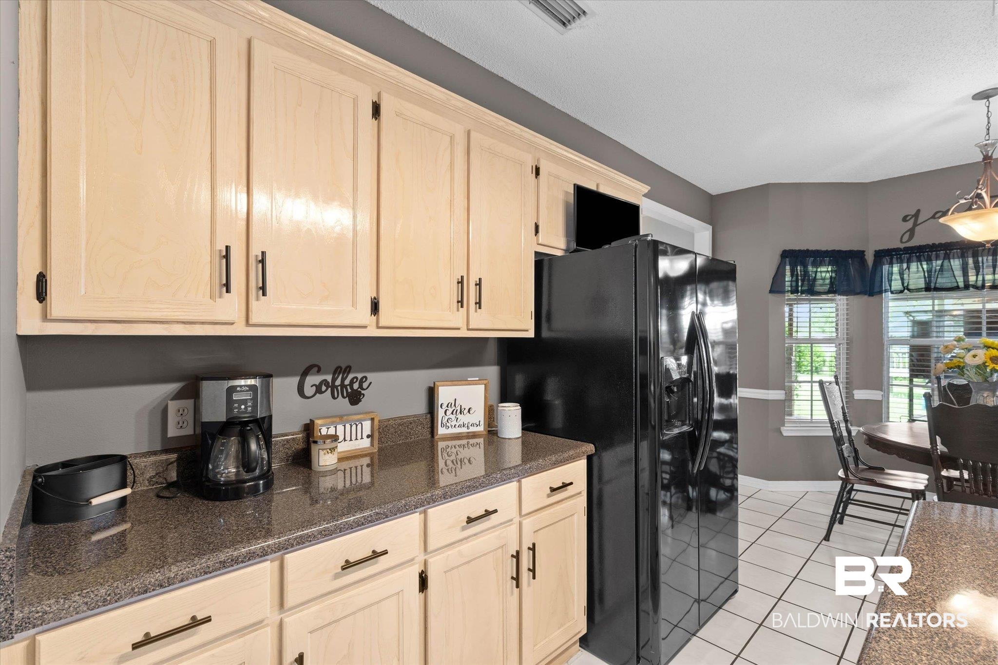 3170 Scott Dairy Loop Road West Mobile, AL 36695 - Photo 6 of 24 Kitchen featuring light-toned cabinetry with dark hardware, dark countertop, and integrated black refrigerator