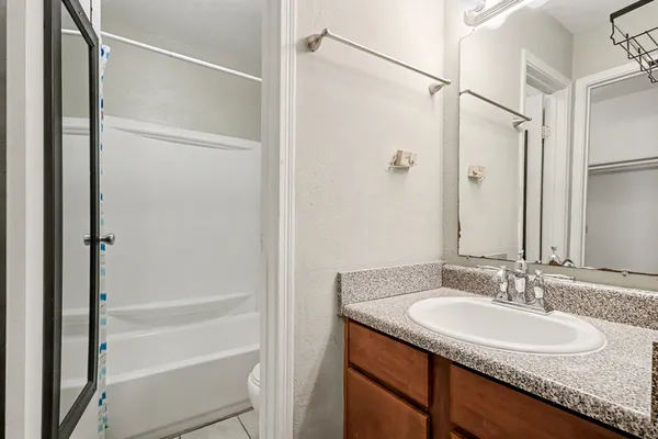 a bathroom with a granite countertop sink shower and a mirror