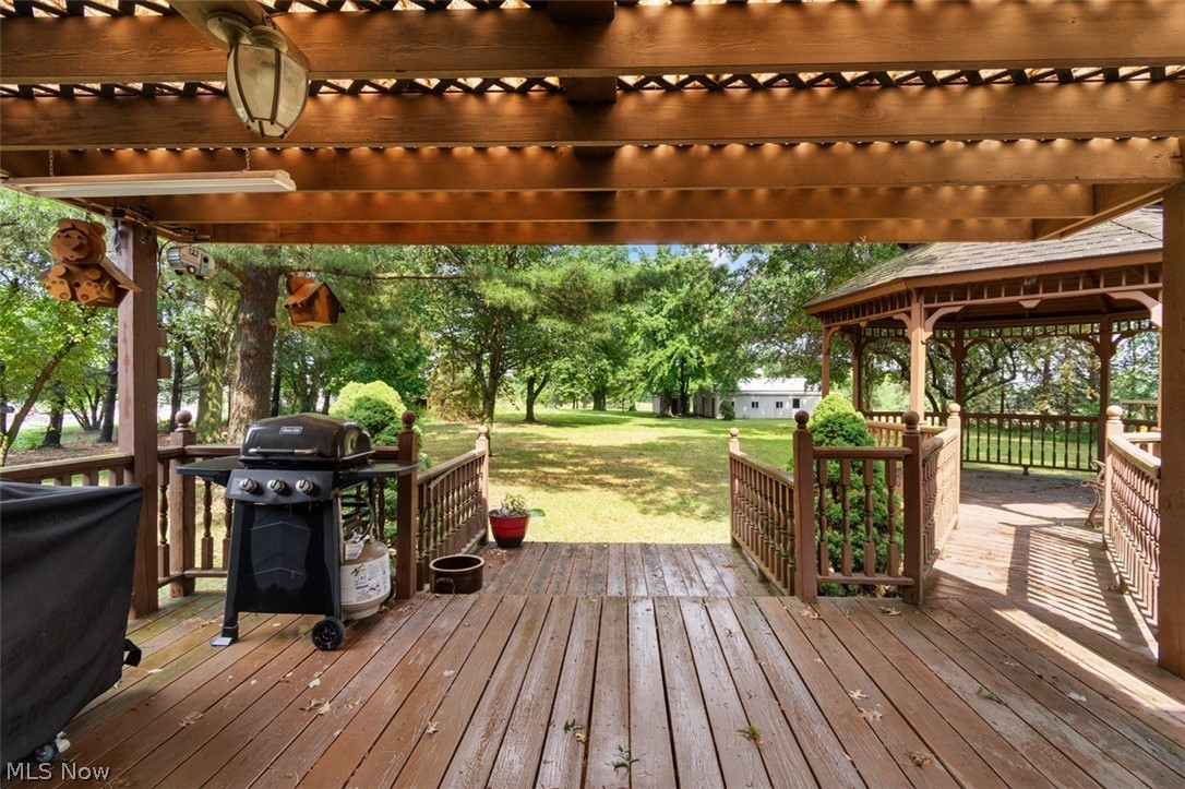 Acme Road Rittman, OH 44270 - Photo 37 of 45 Wooden deck with area for grilling, a pergola, and a lawn