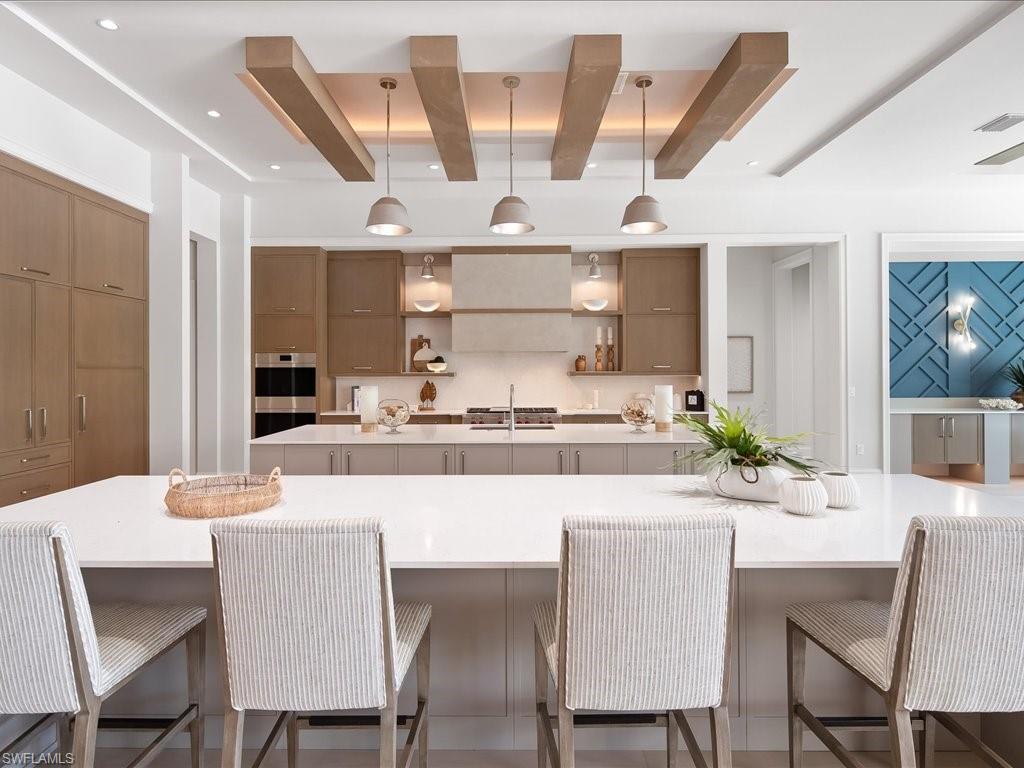 6730 Sable Ridge Lane Naples, FL 34109 - Photo 11 of 50 a room with stainless steel appliances kitchen island granite countertop a dining table chairs and a refrigerator