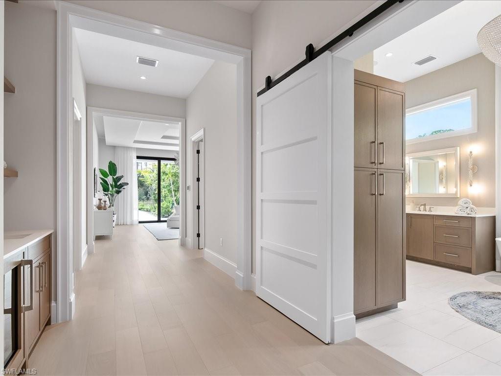 6730 Sable Ridge Lane Naples, FL 34109 - Photo 14 of 50 a view of a hallway with wooden floor and windows