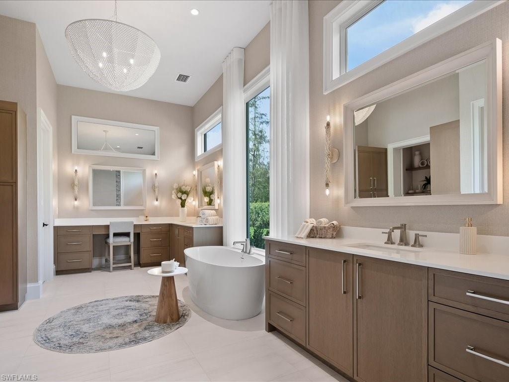 6730 Sable Ridge Lane Naples, FL 34109 - Photo 18 of 50 a large bathroom with a double vanity sink a mirror and a bathtub