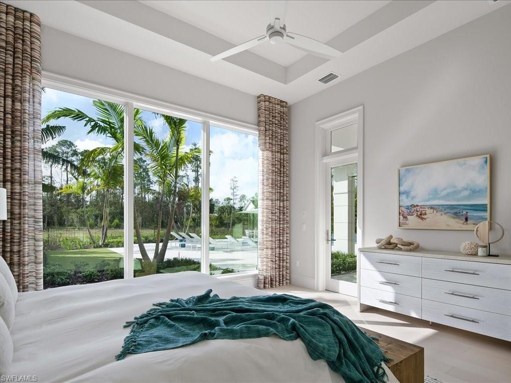 6730 Sable Ridge Lane Naples, FL 34109 - Photo 23 of 50 a bedroom with a bed and large windows