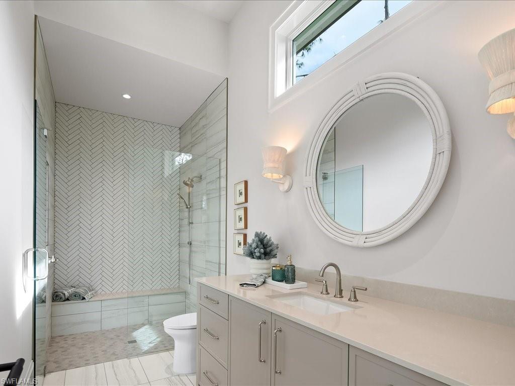 6730 Sable Ridge Lane Naples, FL 34109 - Photo 24 of 50 a bathroom with a toilet a sink a mirror and vanity
