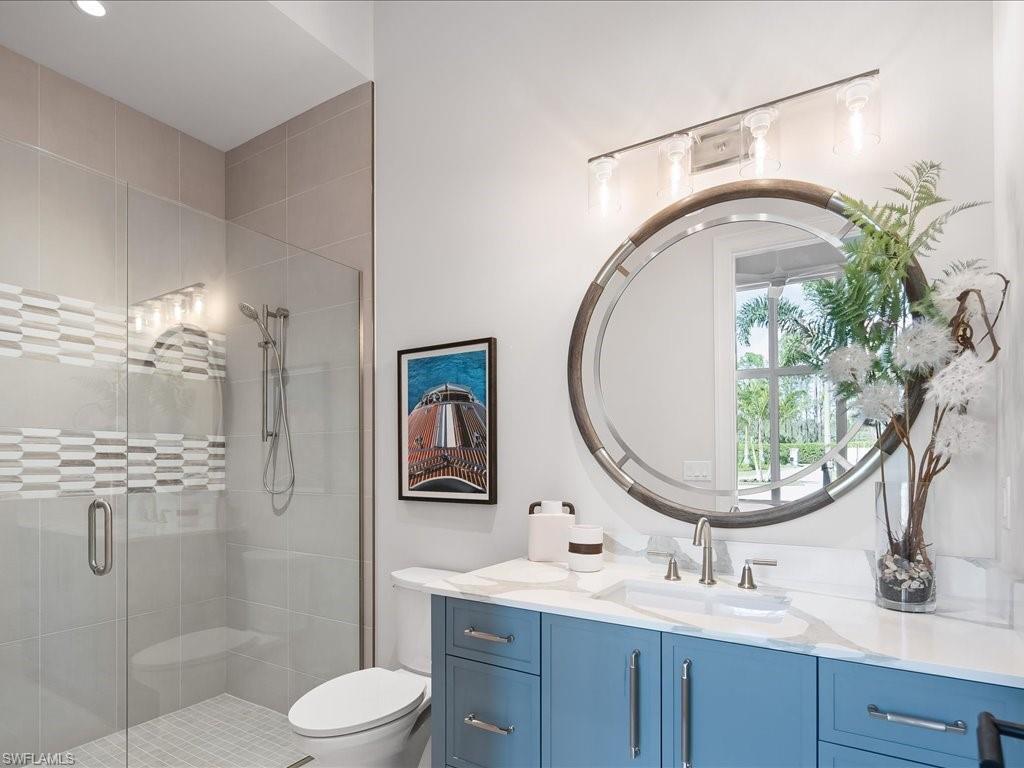 6730 Sable Ridge Lane Naples, FL 34109 - Photo 26 of 50 a bathroom with a sink a mirror a toilet and a shower