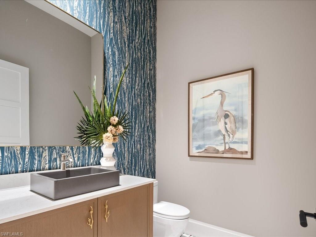 6730 Sable Ridge Lane Naples, FL 34109 - Photo 27 of 50 a bathroom with a toilet a sink and mirror