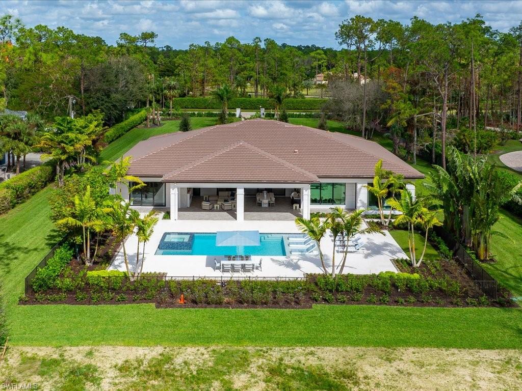 6730 Sable Ridge Lane Naples, FL 34109 - Photo 48 of 50 a view of house with garden and a swimming pool