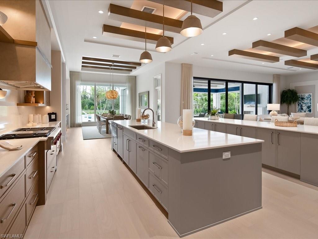 6730 Sable Ridge Lane Naples, FL 34109 - Photo 8 of 50 a large kitchen with stainless steel appliances a lot of counter space and a wooden floors