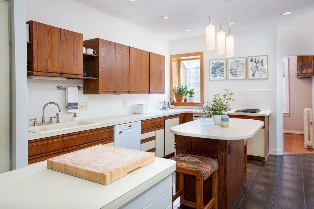 6 Strathmore Road, Unit 3C Brookline, MA 02445 - Photo 7 of 21 a kitchen with stainless steel appliances kitchen island granite countertop a sink a stove a dining table and chairs