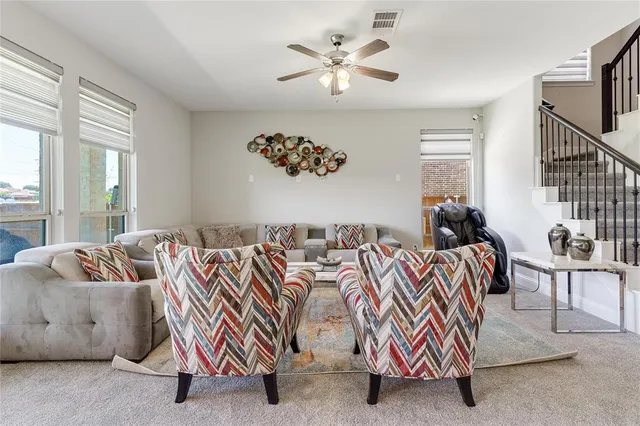 a living room with furniture and a large window with garden view