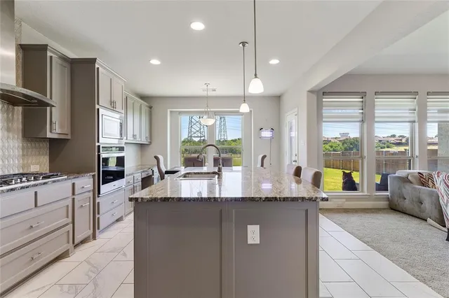 a kitchen with stainless steel appliances granite countertop a sink stove and refrigerator