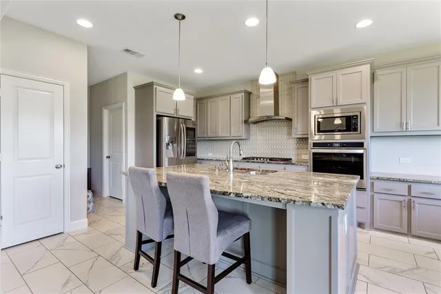 a kitchen with a refrigerator a stove a sink and chairs