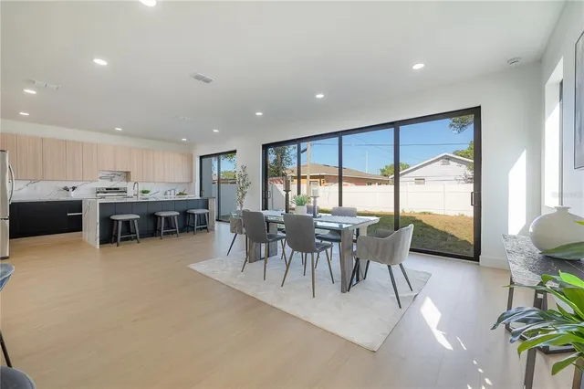 a kitchen with refrigerator and chairs