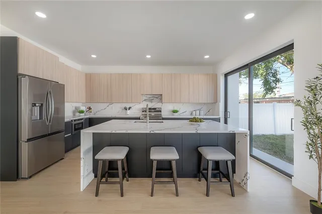a large kitchen with kitchen island a large window in it