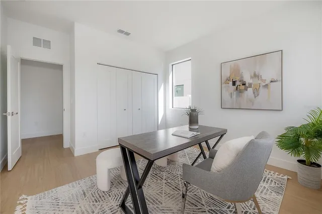 a spacious bedroom with a bed and a lamp