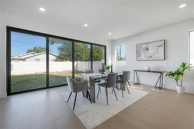 a dining room with furniture and a floor to ceiling window