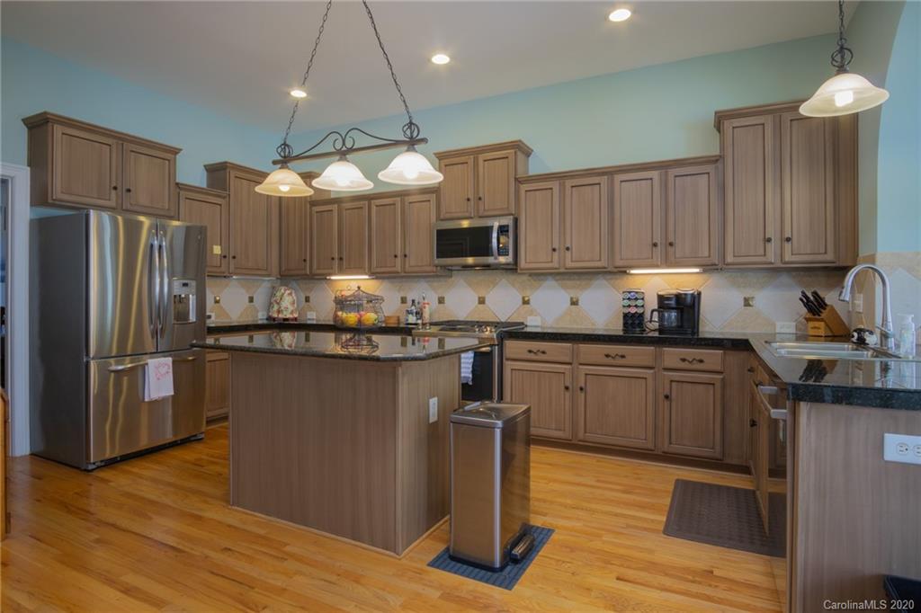 3236 Colonel Springs Way Fort Mill, SC 29708 - Photo 16 of 45 a kitchen with granite countertop wooden floors stainless steel appliances and a sink