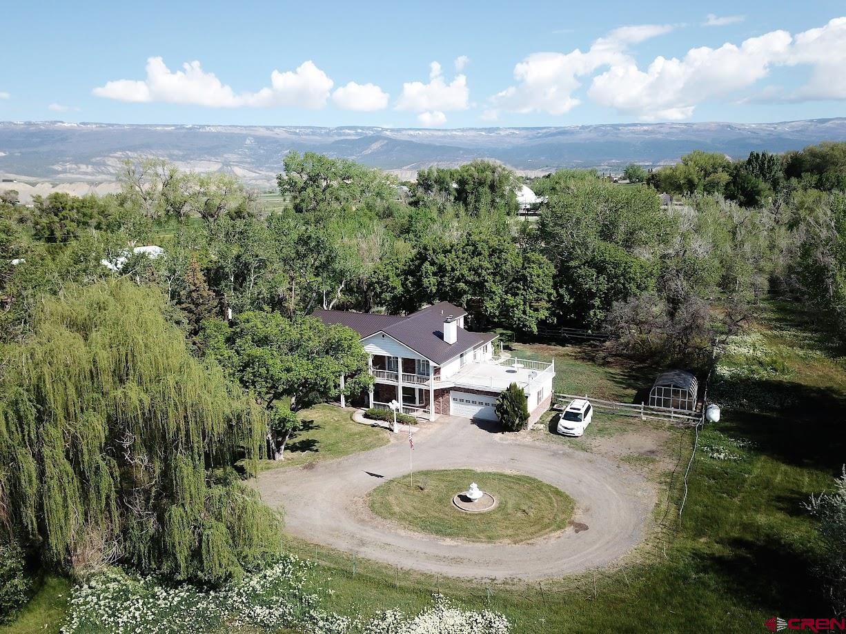 an aerial view of residential houses with outdoor space and trees
