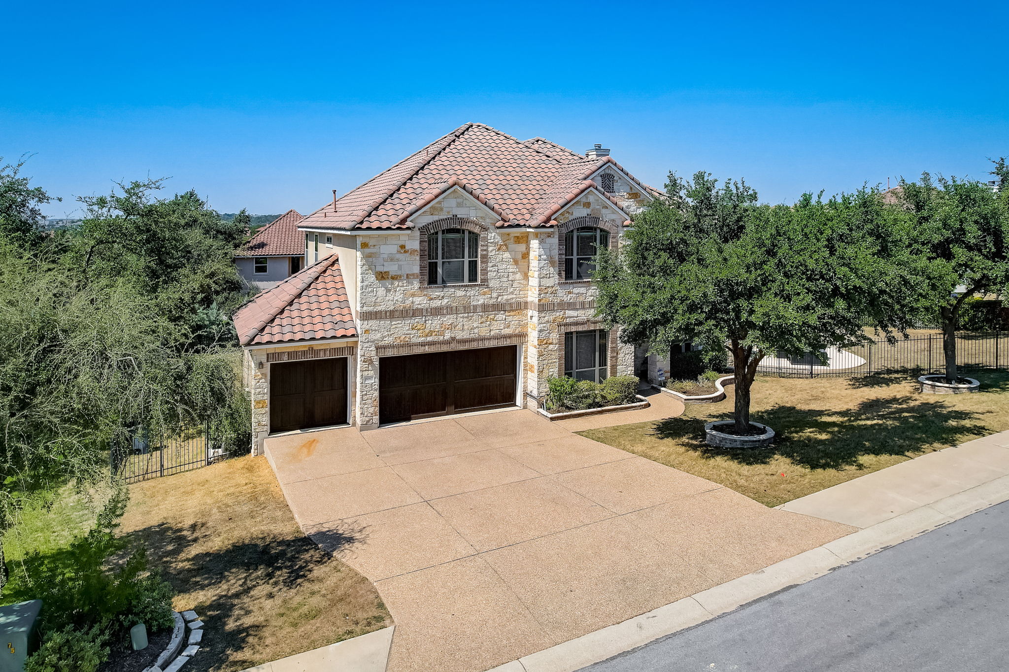 16012 Spillman Ranch Loop Austin, TX 78738 - Photo 1 of 38 Experience modern living in this elegant home with a spacious driveway and attached garages.