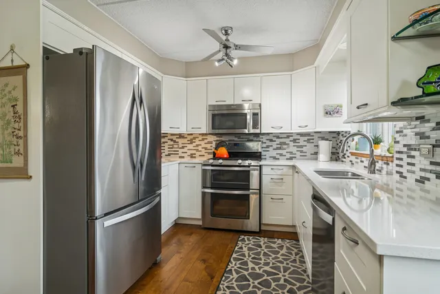 a kitchen with stainless steel appliances granite countertop a refrigerator stove and sink