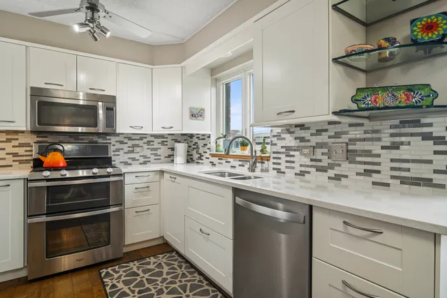 a kitchen with stainless steel appliances granite countertop a sink and stove top oven
