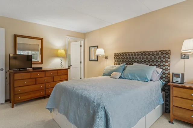 a bedroom with a bed and a mirror on dresser