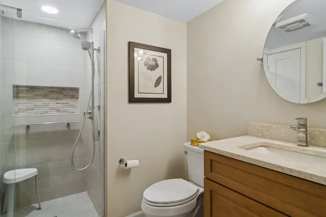 a bathroom with a granite countertop toilet sink and mirror