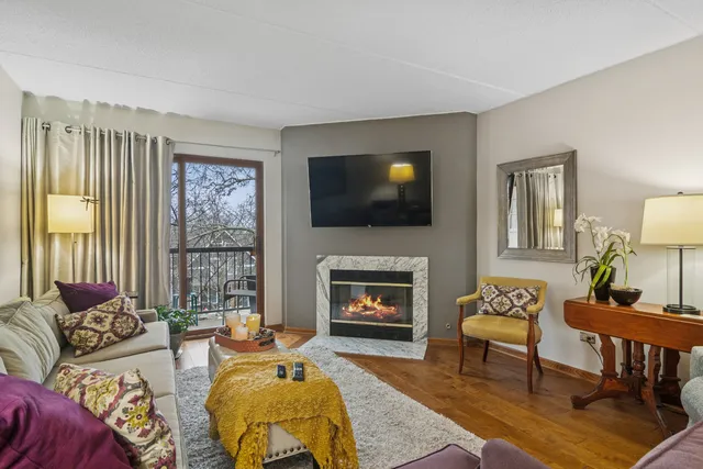 a living room with furniture a fireplace and a flat screen tv