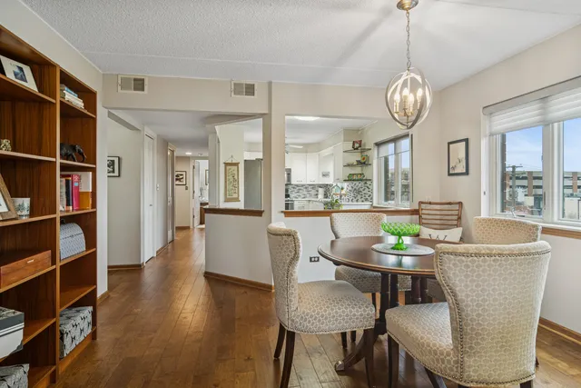 a view of a dining room with furniture a rug and wooden floor