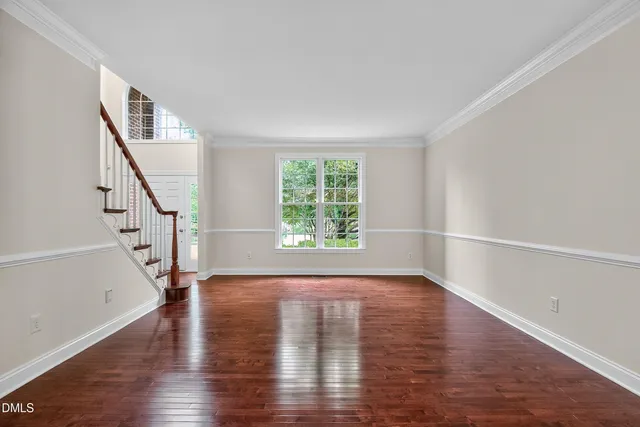 a view of a room with wooden floor chandelier and a window