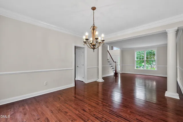a view of an empty room with wooden floor fireplace and a window