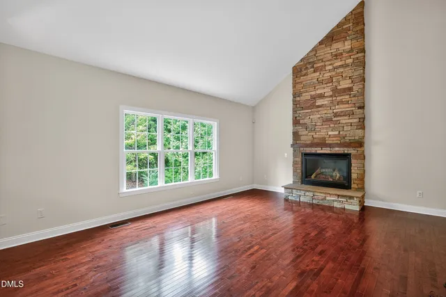 a view of a living room and a kitchen with wooden floor