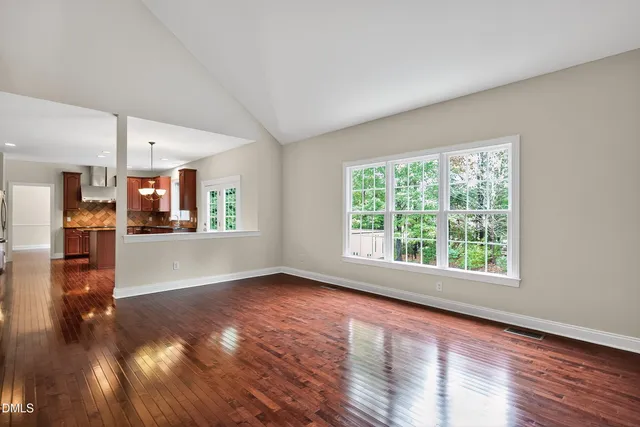 a kitchen with stainless steel appliances granite countertop a sink a window and wooden floor