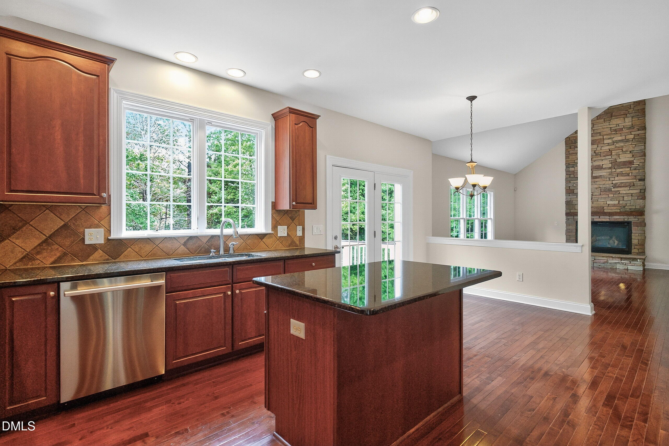 9441 Collingdale Way Raleigh, NC 27617 - Photo 19 of 54 a kitchen with stainless steel appliances granite countertop a sink a window and wooden floor
