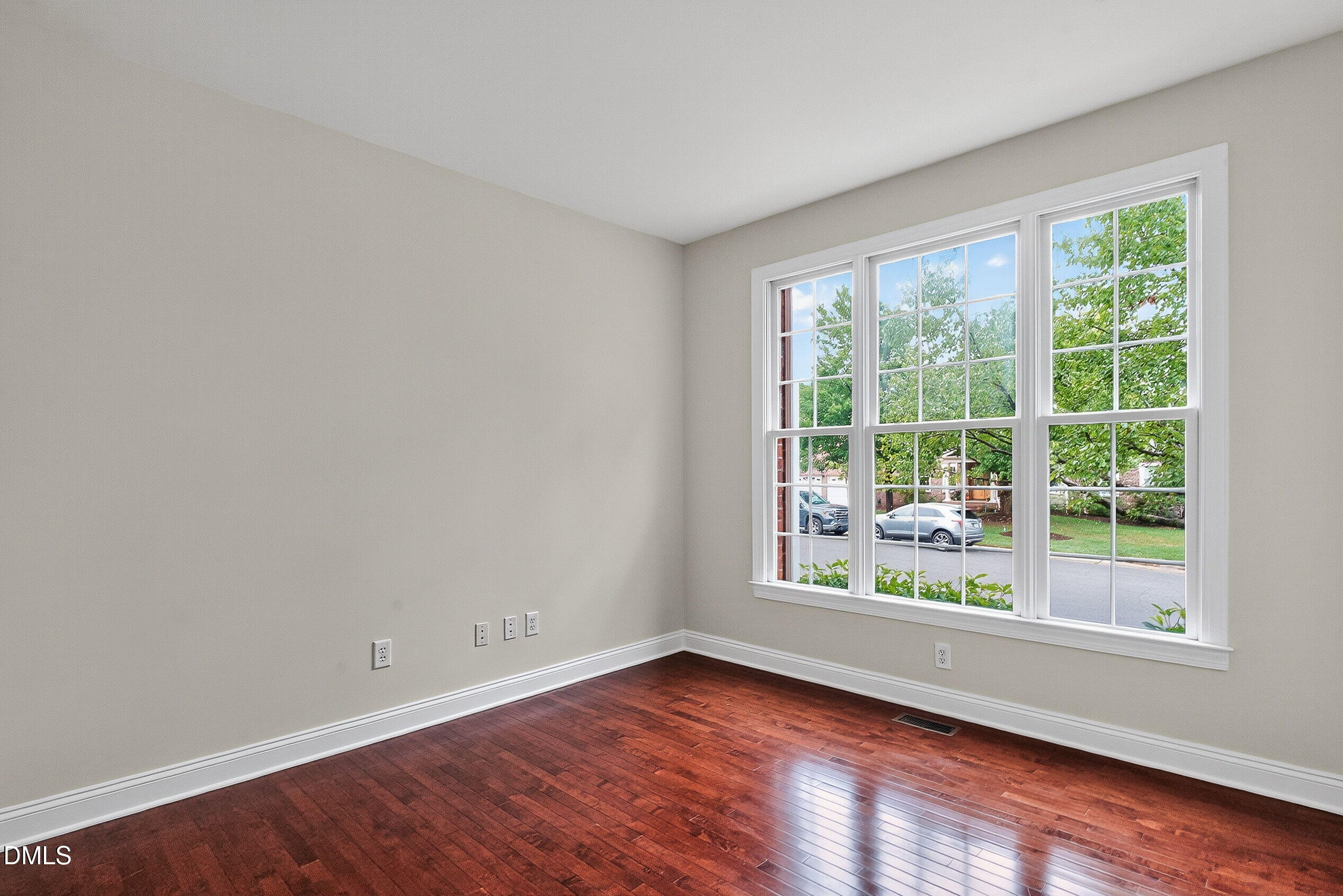 9441 Collingdale Way Raleigh, NC 27617 - Photo 6 of 54 a view of an empty room with wooden floor and a window