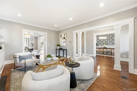 a living room with furniture a wooden floor and next to a window