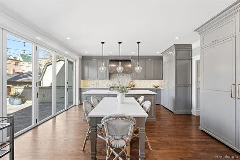 a kitchen with stainless steel appliances a dining table chairs and chandelier