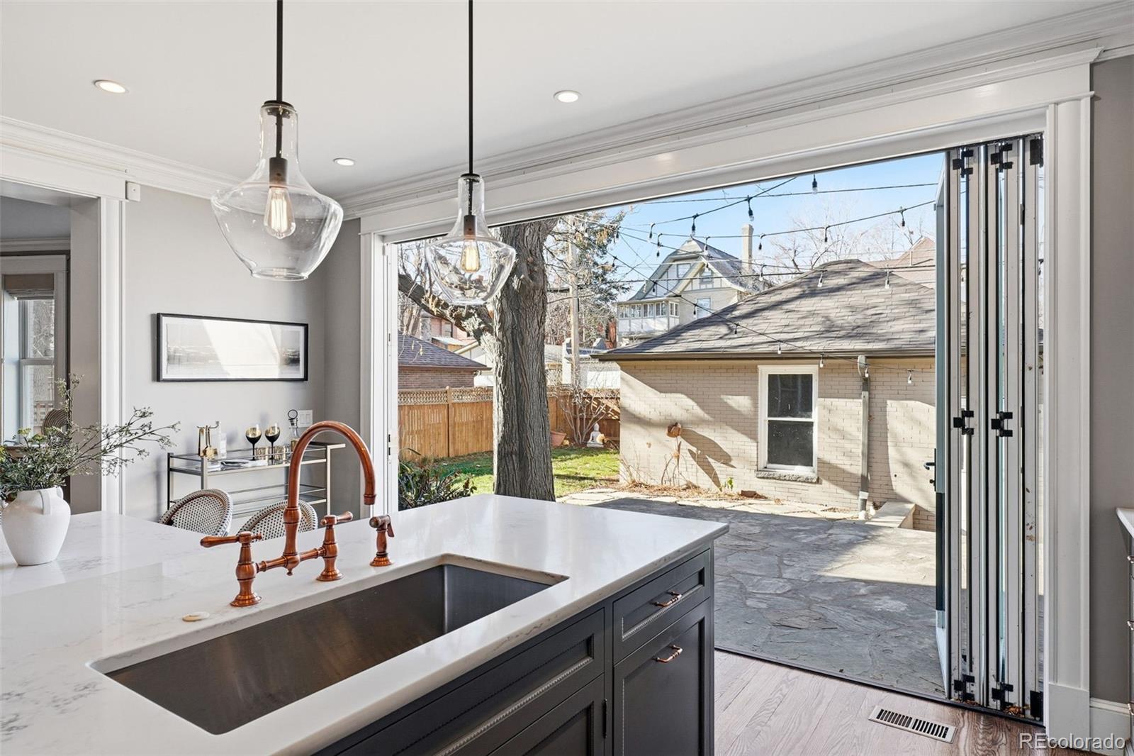 1257 Fillmore Street Denver, CO 80206 - Photo 14 of 50 a kitchen with a sink a counter top space and living room view