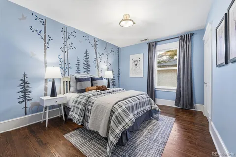 a bedroom with a large bed and windows