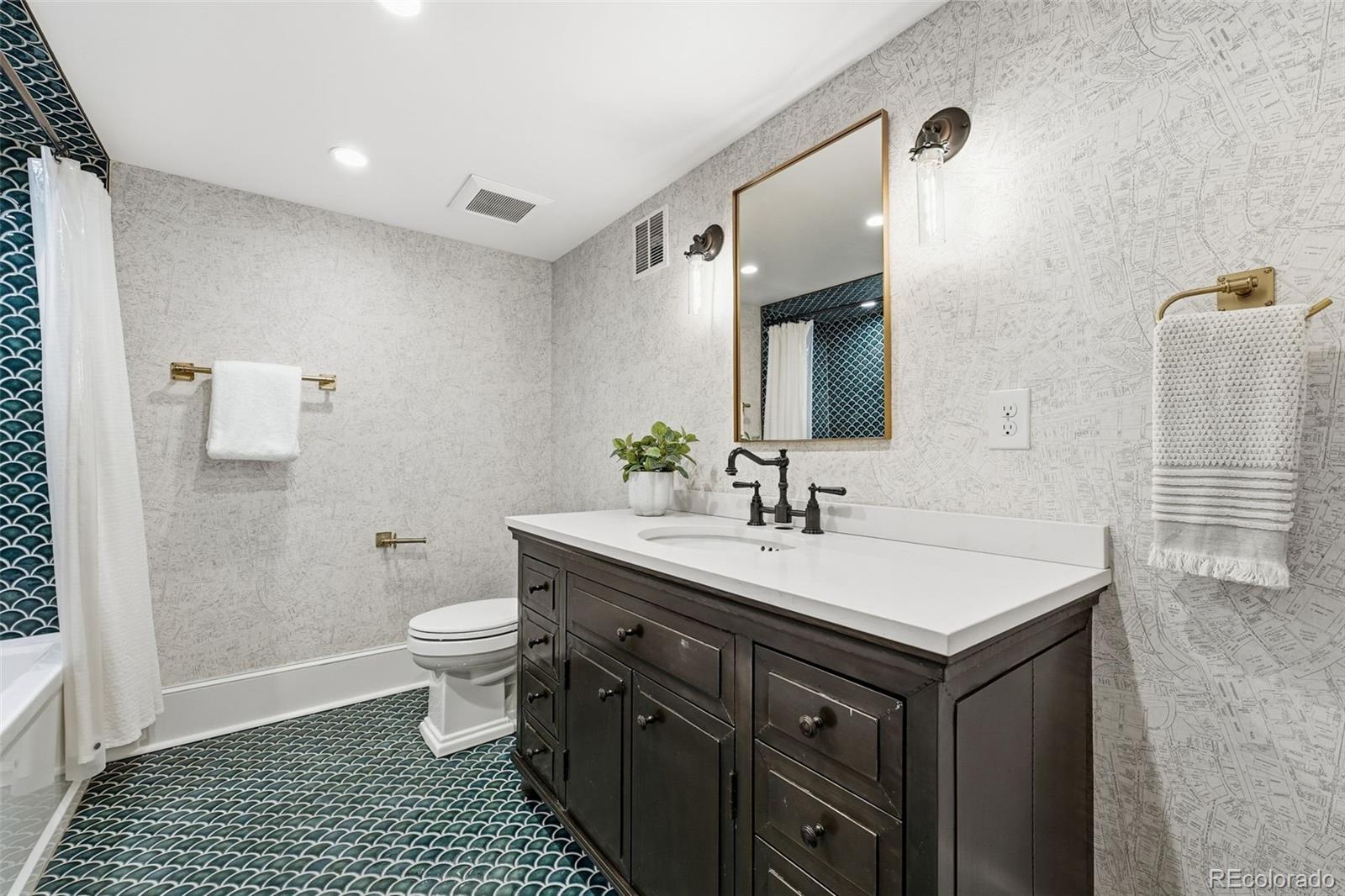 1257 Fillmore Street Denver, CO 80206 - Photo 46 of 50 a bathroom with a sink a toilet a mirror and shower