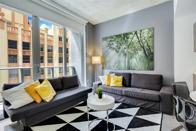 a living room with furniture and a floor to ceiling window